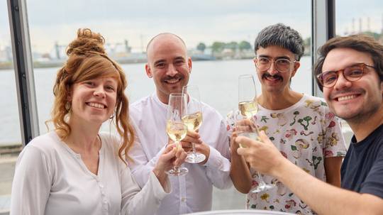Drei Personen stoßen mit Sektgläsern an