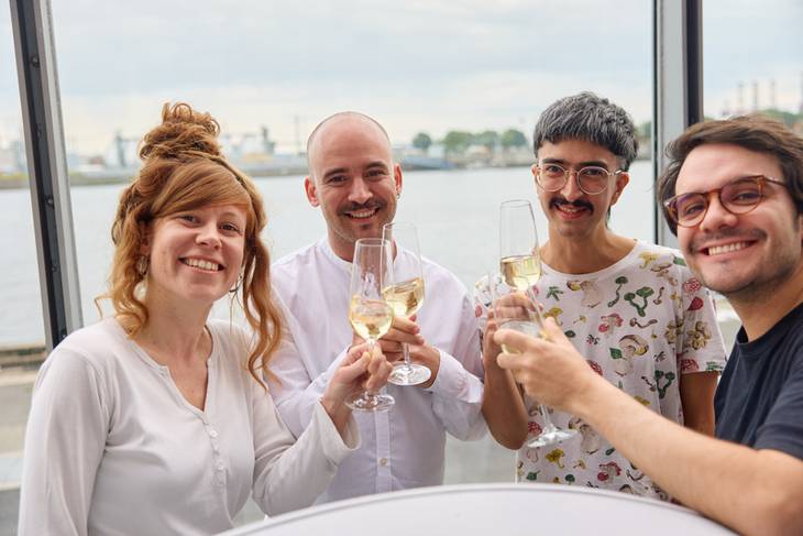 Drei Personen stoßen mit Sektgläsern an