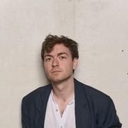 Foto  eines Mannes mit dunklen Jacket und weißen Hemd.