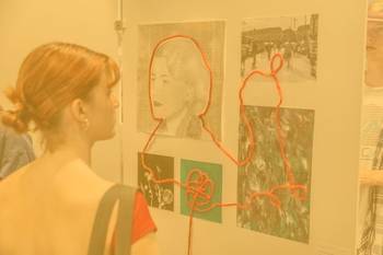 Bild mit einer jungen Frau, die ein Bild in einer Ausstellung betrachtet, Foto mit gelbem Overlay