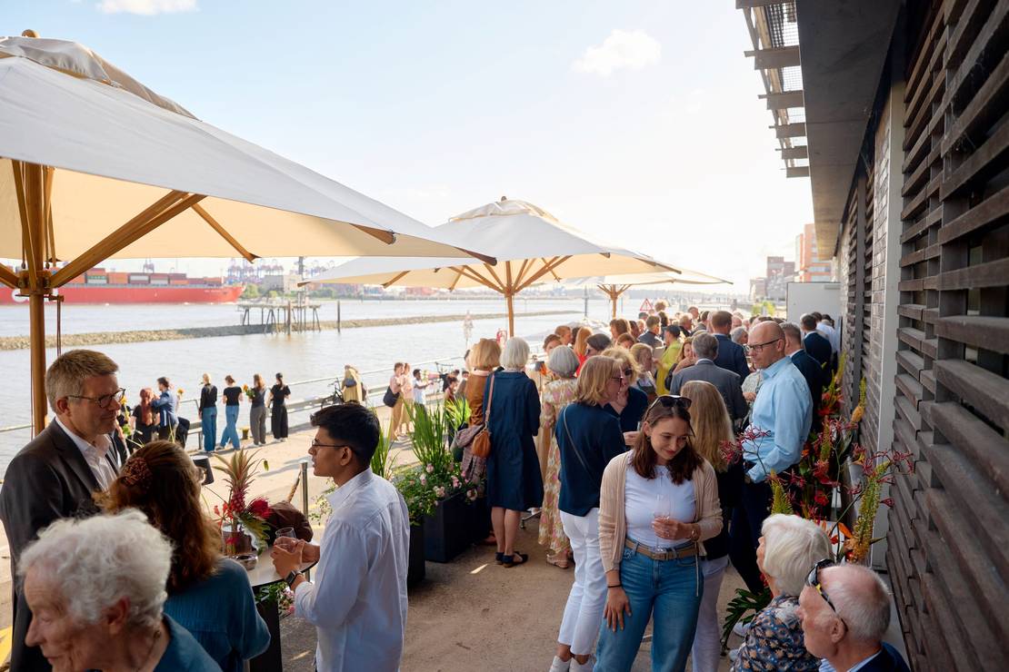 Foto mit Blick auf die Hafenkant vor der Stiftung, es stehen viele Leute beisammen und unterhalten sich.