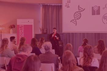 Bild eines vortragenden Stipendiaten vor einem Plenum von Stipendiat:innen, Foto mit rotem Overlay und Beschriftung: Master Plus