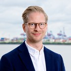 Porträt von Carl Johann Claussen, Vorstandsvorsitzender der Claussen-Simon-Stiftung, vor Hafenpanorama