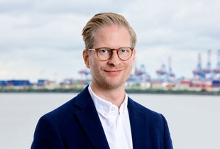 Porträt von Carl Johann Claussen, Vorstandsvorsitzender der Claussen-Simon-Stiftung, vor Hafenpanorama