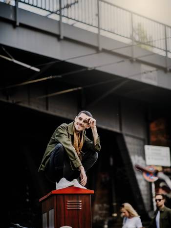 Porträt von Daniel Bucurescu, auf einem Stromkasten hockend