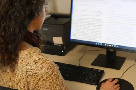 Foto von Eileen am Computer bei der Arbeit an einem Dokument.