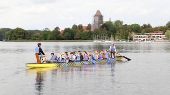 Foto mit Stipendiat:innen im Drachenboot auf dem Ratzeburger See beim Stipendiat:innentreffen