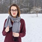 Halbporträt der Komponistin Rachel C. Walker, mit Schal und Mantel in einer Winterlandschaft stehend