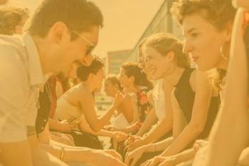 Bild mit stART.up-Stipendiat:innen zweier Jahrgänge gegenüber sitzend im Austausch, Foto mit gelbem Overlay