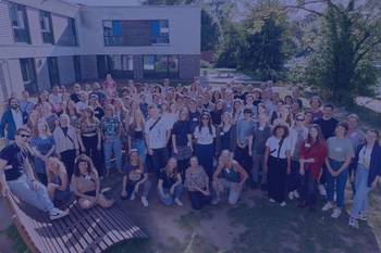 Bild mit den Teilnehmenden des Stipendiat:innentreffens in Ratzeburg vor der Jugendherberge, Foto mit blauem Overlay