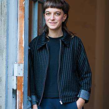 Porträt der Regisseurin Anja Kerschkewicz, an einer Wand lehnend