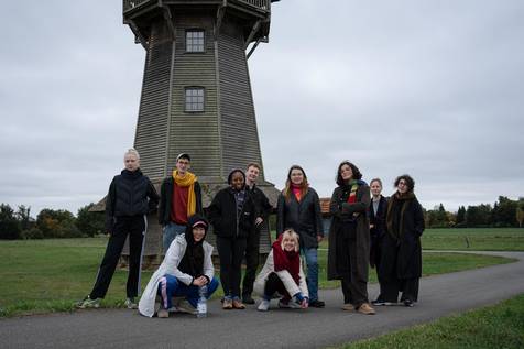 Gruppenfoto von einer Gruppe Leute vor einer alten Mühle.